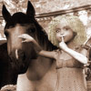 Little girl shushes as she leads a horse home.