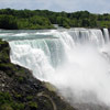 Large waterfall with mist and rocks.
